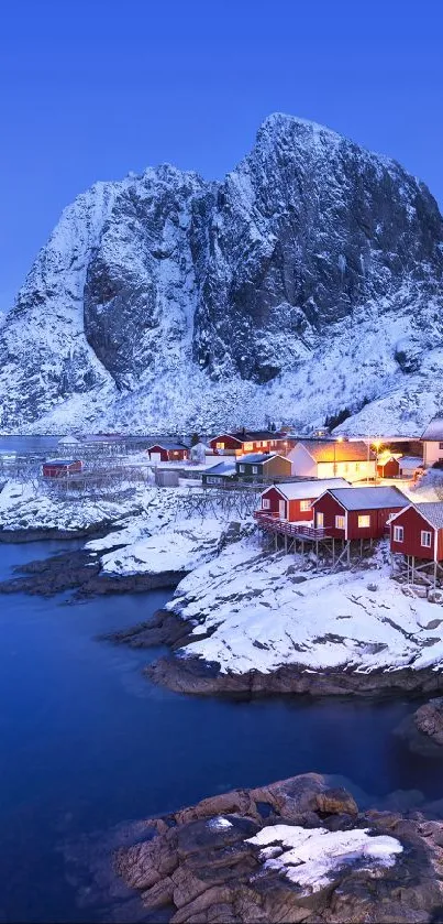 Snow-covered mountains and fjord in evening light.