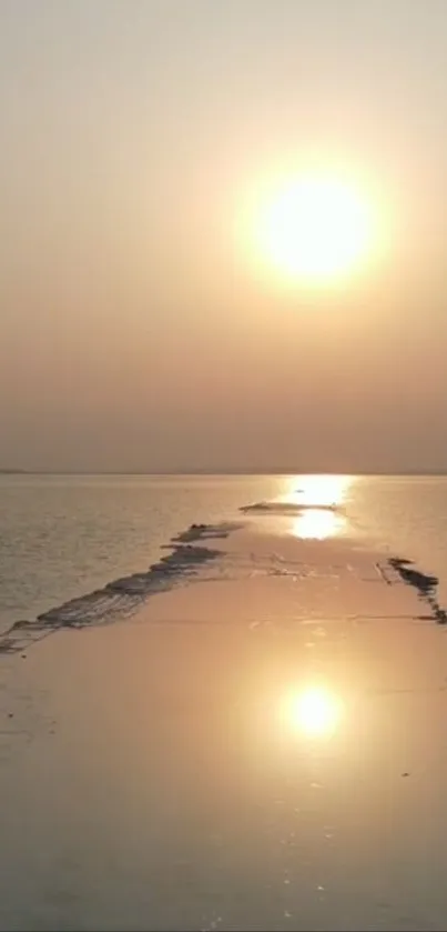 Serene sunrise over a beach pathway with golden reflections on calm waters.