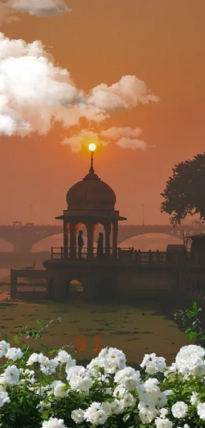 Sunrise over a river with white flowers and orange sky.