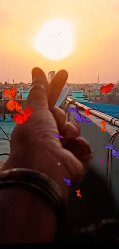 Hand gesture towards sunset with vibrant butterflies.