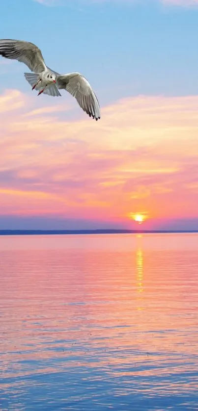 Seagull flies over serene sunset ocean with pink sky.