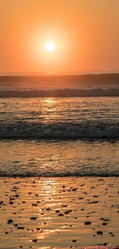 Serene beach at sunset with warm orange glow.