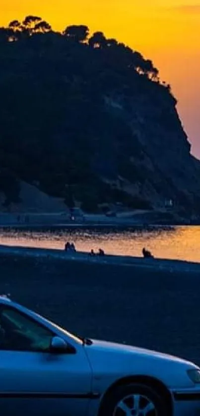 Sunset over a serene beach with silhouetted mountain and cars.