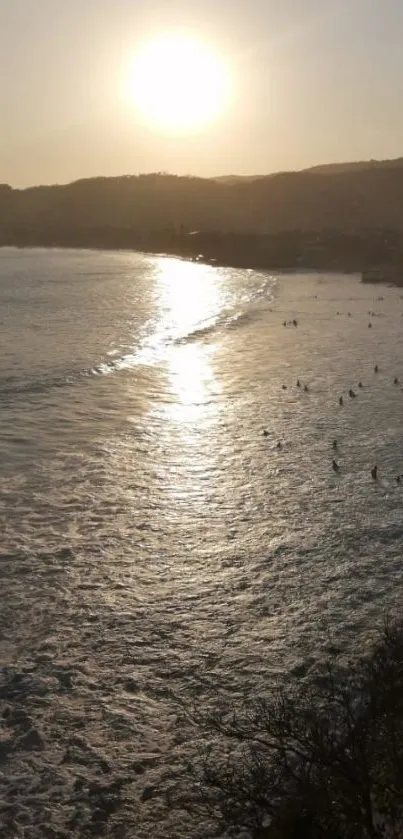 Serene beach at sunset with golden skies and tranquil waves.