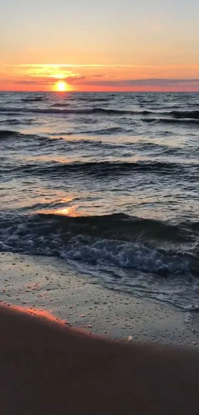 Beautiful sunset at the beach with gentle ocean waves and glowing horizon.