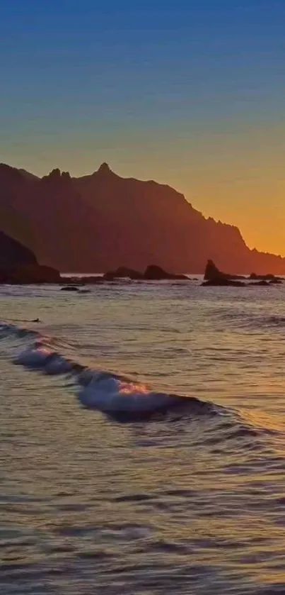 Sunset over a tranquil beach with waves gently lapping the shore.