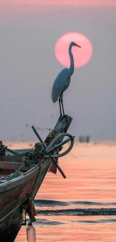 Heron on boat at sunset with pink sky and reflection on water.