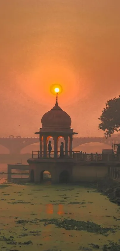 Sunset behind a monument with orange hues sky and tranquil surroundings.