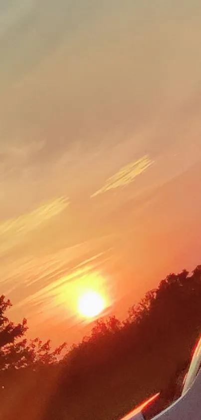 Serene sunset view from a car window, featuring warm orange hues.