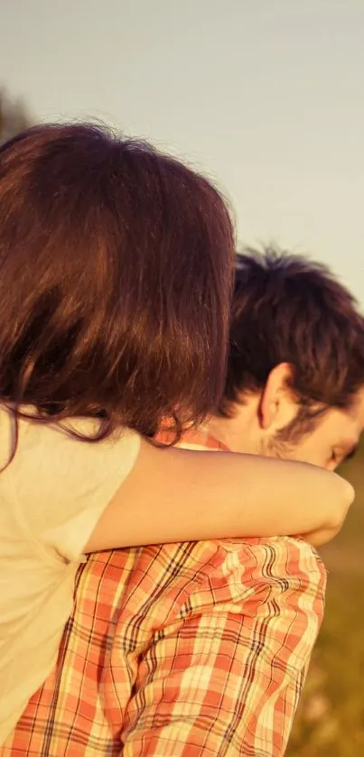 Couple embraces in a field during sunset, capturing a serene and romantic moment.