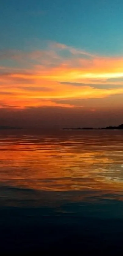 Vibrant sunset with hot air balloon over water.