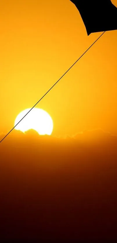 Silhouette of a kite against a vibrant sunset backdrop, evoking serenity.