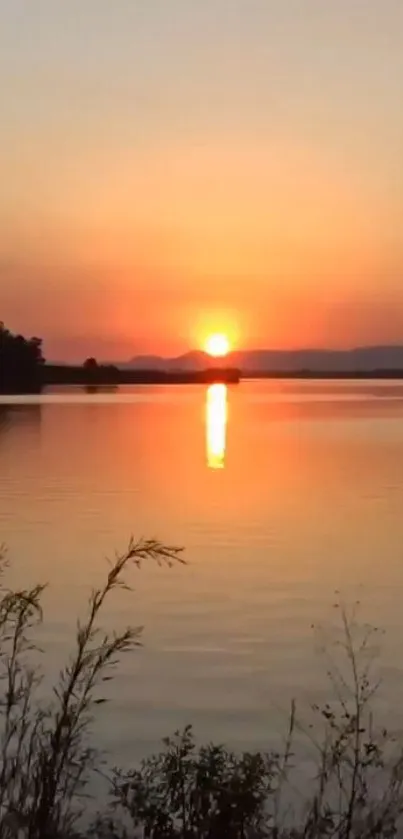 Beautiful sunset over a calm lake with orange and yellow hues in the sky.