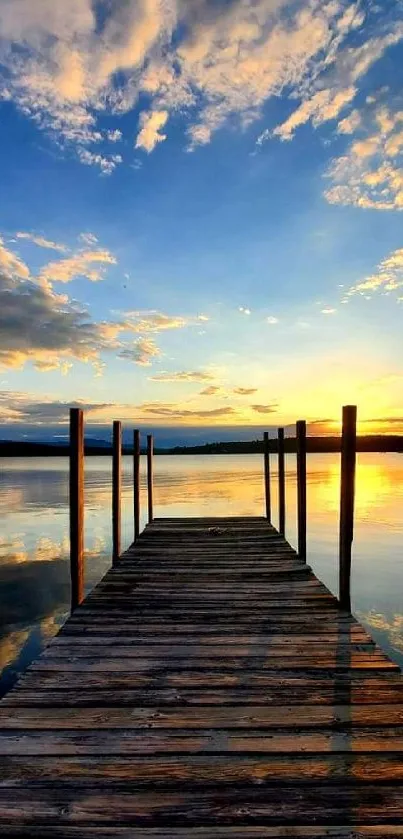 Wooden dock leading to a tranquil lake at sunset with a vibrant sky.