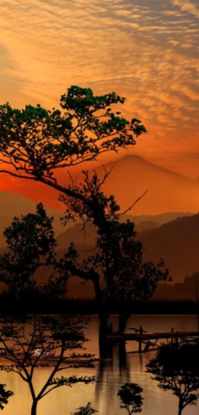 Serene lake scene at sunset with silhouetted trees and orange sky.