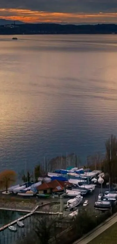 Lakeside sunset with boats on serene water.