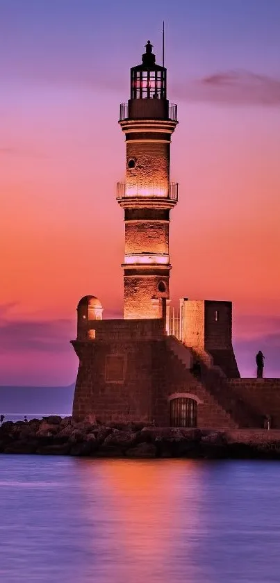 Lighthouse silhouette against a colorful sunset sky over a tranquil ocean.