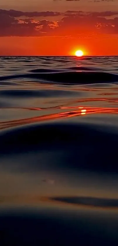 Orange sunset with ocean waves reflecting vibrant colors.