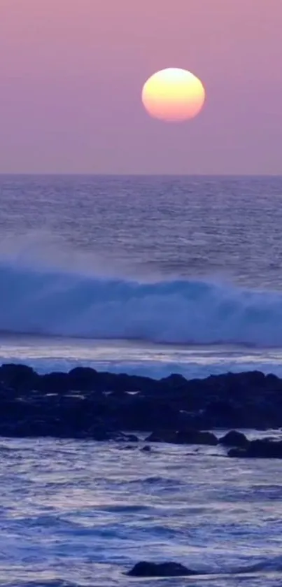 Purple sunset over ocean with crashing waves.