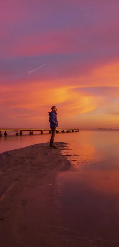 Stunning sunset with vibrant orange and purple hues over a tranquil beach landscape.