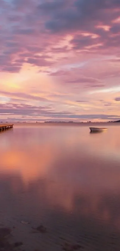 A tranquil sunset with a pastel pink sky reflecting on calm waters.