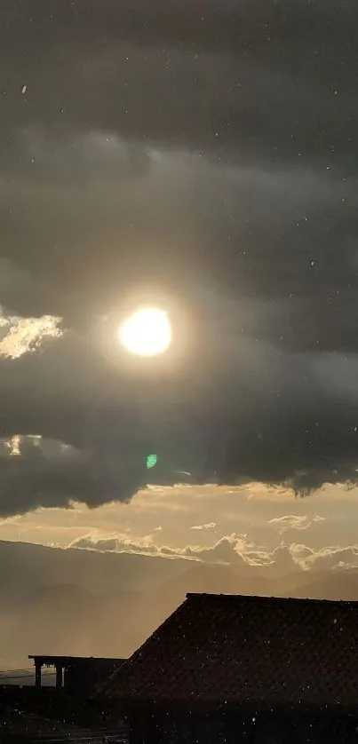 Sunset over mountains with gray clouds casting a serene, calming atmosphere.