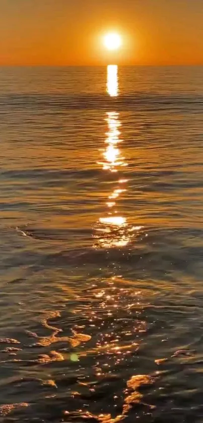 Vibrant orange sunset reflecting on tranquil ocean waters.