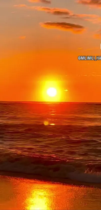 Vibrant sunset over ocean with orange sky and reflections on the water.