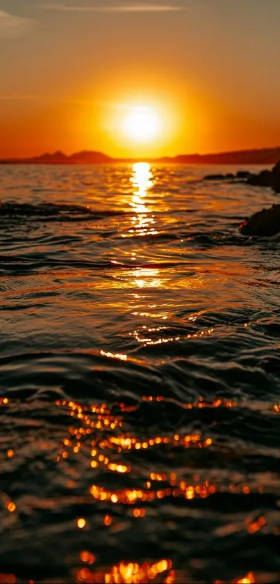 Serene sunset over ocean reflecting on water surface.