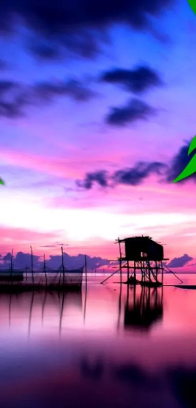 Serene sunset over water with vibrant purple sky and silhouetted hut.