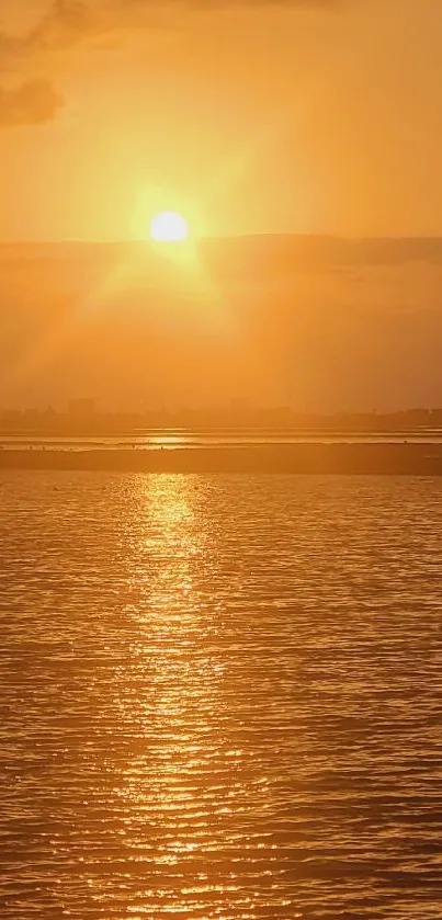 Tranquil sunset over calm water with orange and golden hues.