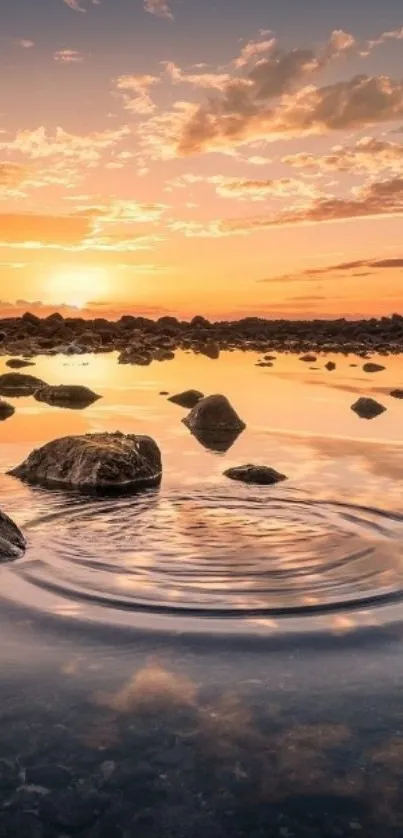 Serene sunset over water with rocks reflecting colors.