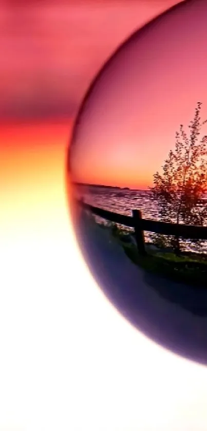 Sunset reflection in a glass sphere with vibrant seascape.