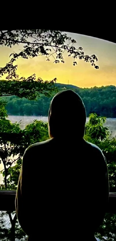 Silhouette by lake at sunset with serene natural backdrop.