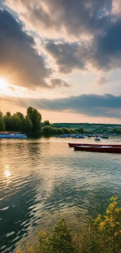 Sunset over a serene river with boats and trees reflecting in calm waters.