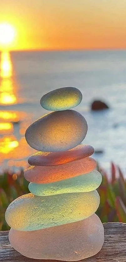 Stacked stones with sunset ocean backdrop.