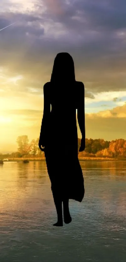 Silhouette of person standing by a serene lake at sunset with warm colors.