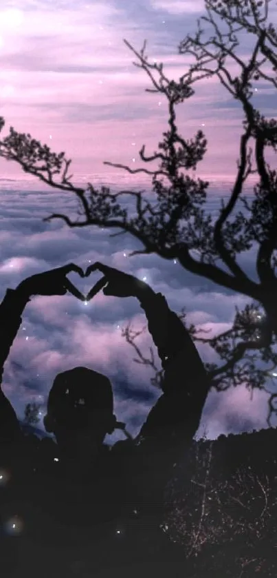 Silhouette forming heart against sunset sky and clouds.