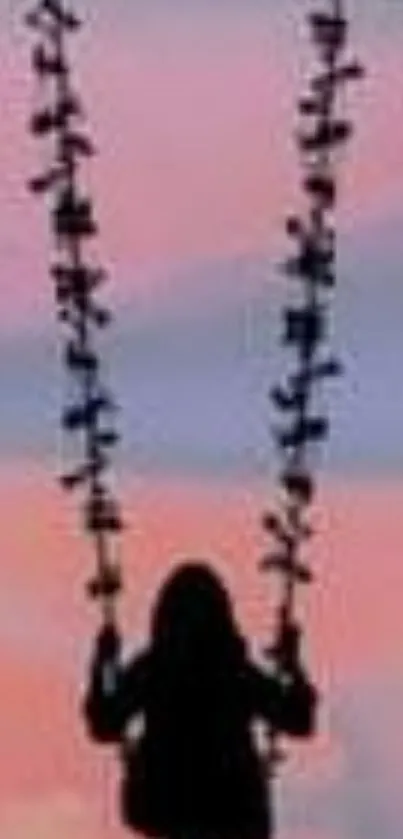 Silhouette of a person on a swing with a pastel sunset sky background.