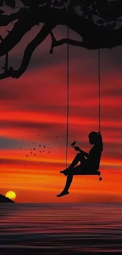 Silhouette swing at sunset over ocean waters.