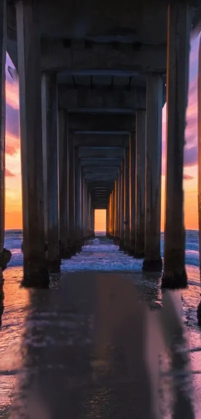 Beautiful sunset under a pier with ocean reflections.