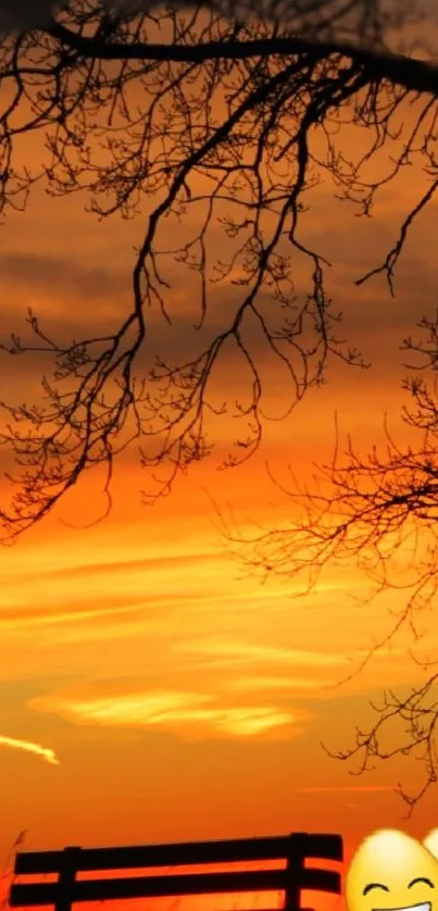 Mobile wallpaper showing sunset with tree branches and smiling emojis.