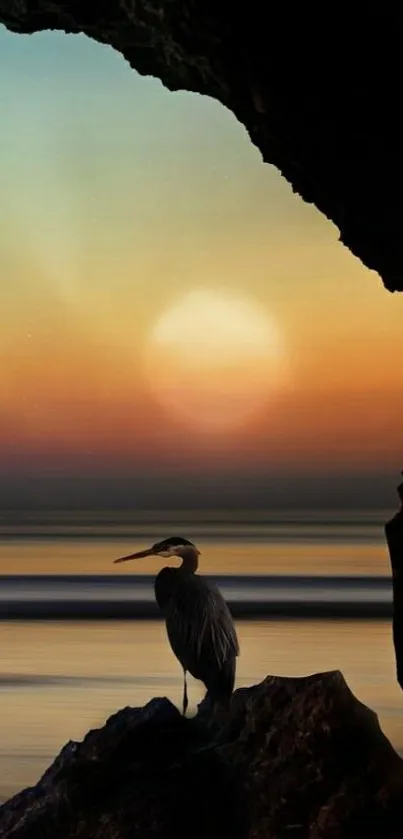 Stunning sunset with a silhouetted heron on rocks.