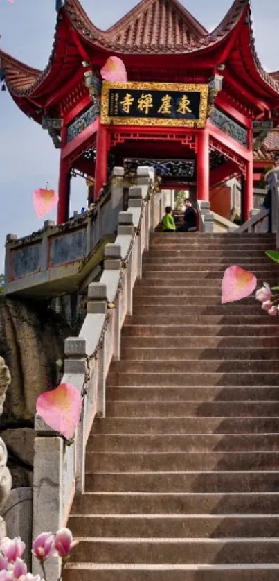 Red temple steps with flowers and statue.