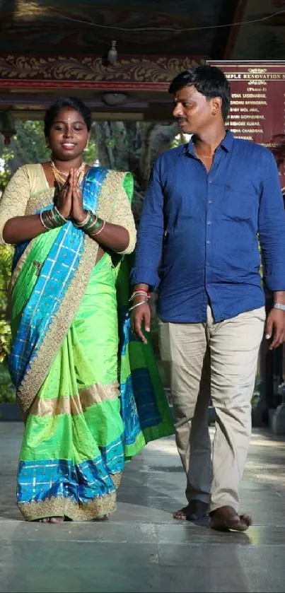 Two people walking in a colorful temple setting.