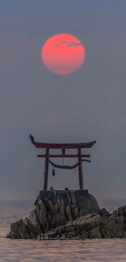 Pink sunset over ocean with Torii gate.