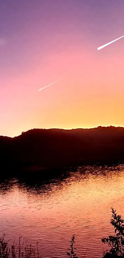 Panoramic twilight lake with sunset glow and silhouetted hills.