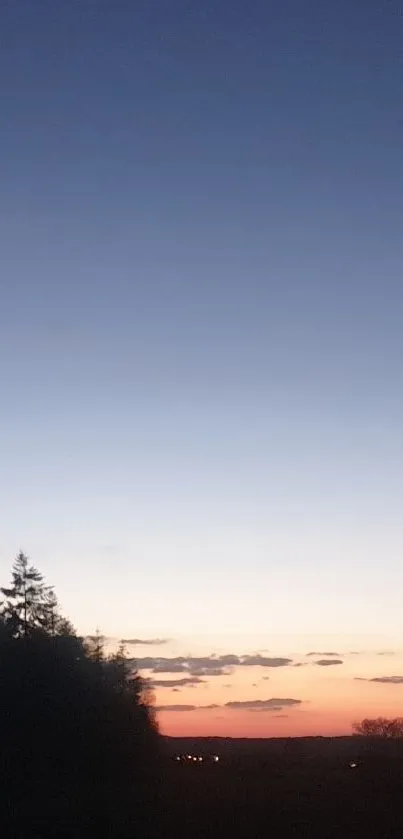 Serene twilight landscape with trees and barn silhouettes against a gradient sky.