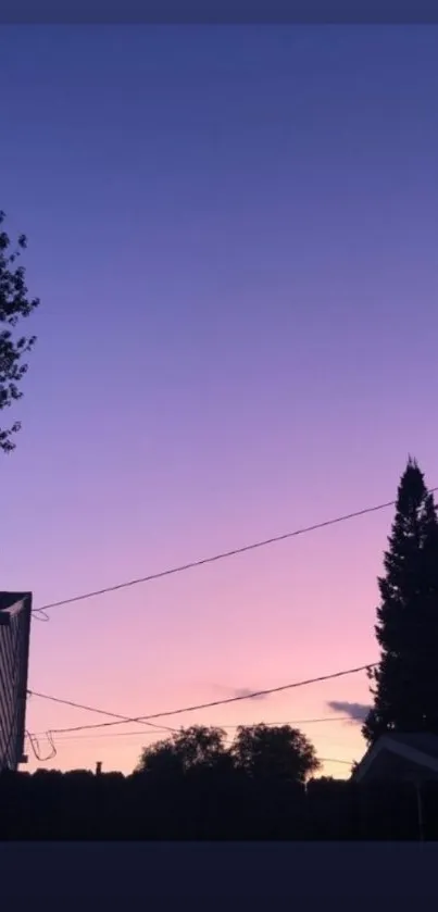 Serene twilight sky with silhouette of trees and houses in purple and pink gradient.