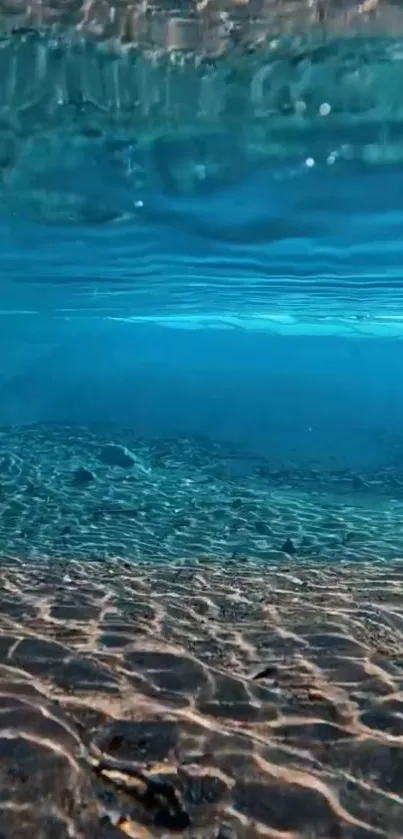 Underwater view of serene ocean landscape with clear blue water and sandy seabed.